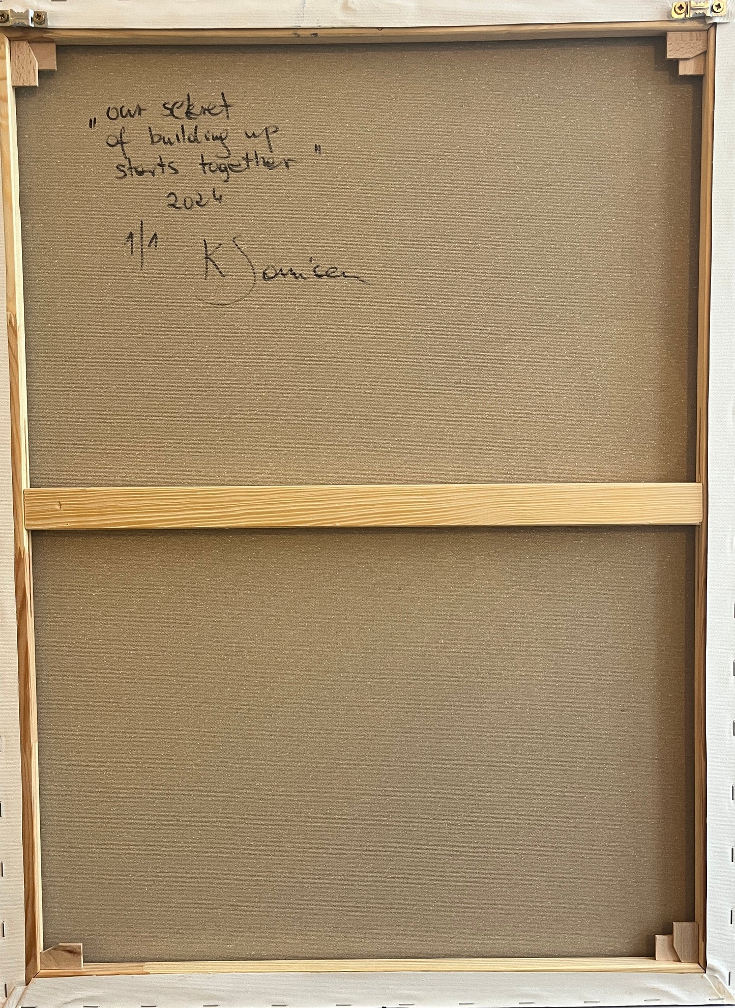 Back of a painting with text and signature, framed in wood.