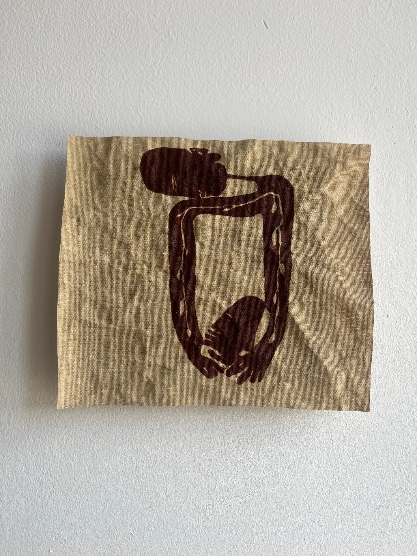 Abstract painting on a crumpled textile against a white wall